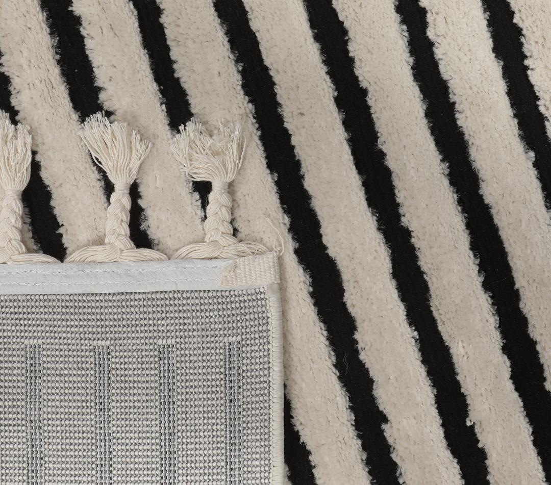 Cream white rug with black geometric lines and fringe