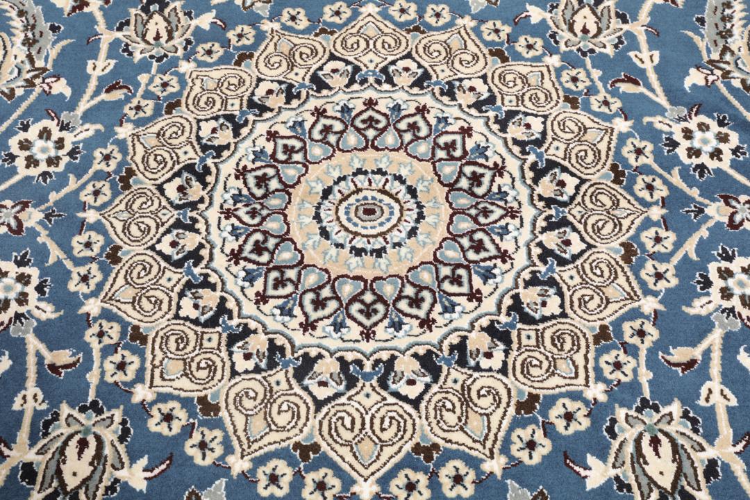 Et firkantet håndknyttet Nain-tæppe med en dybblå bund, indviklede cremefarvede blomstermønstre og en traditionel kant, der stammer fra Mellemøsten.