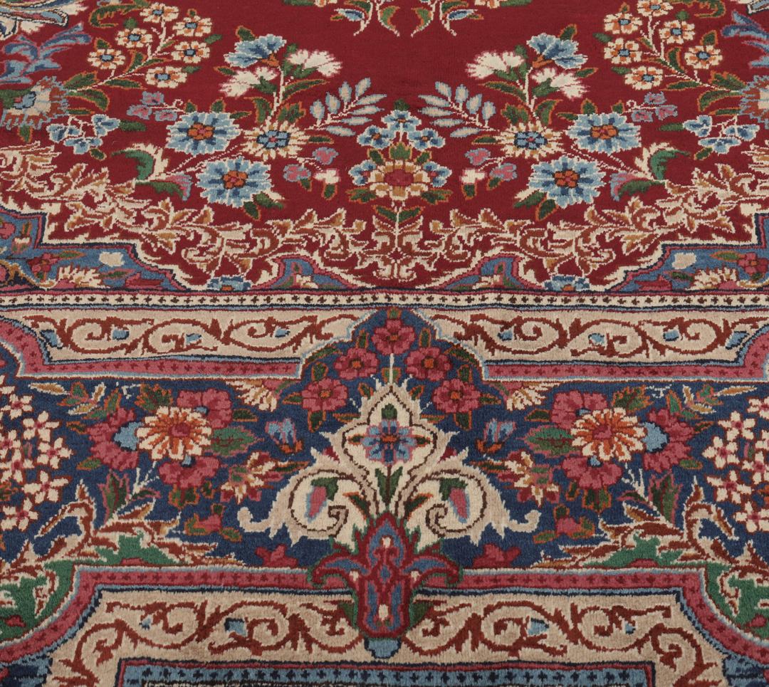 Een groot, handgeknoopt Yazd-tapijt uit het Midden-Oosten met een donkerrood veld en bloemmotieven.