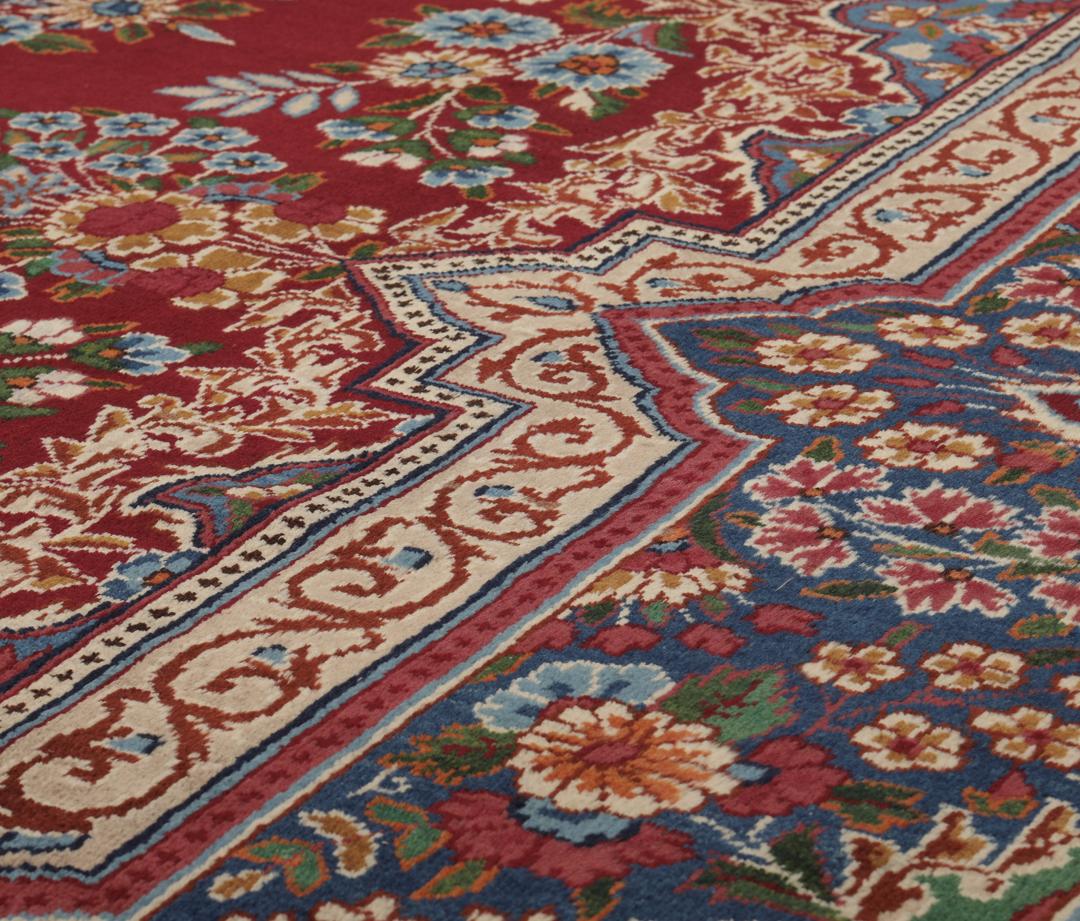 Een groot, handgeknoopt Yazd-tapijt uit het Midden-Oosten met een donkerrood veld en bloemmotieven.