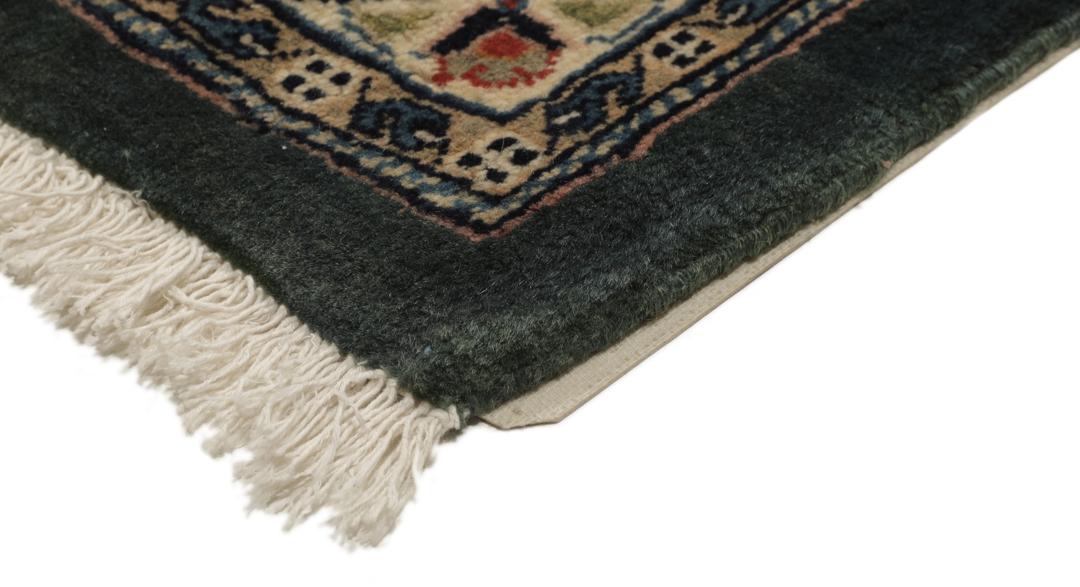 A hand-knotted Middle Eastern Sarough rug with a dark-blue field and floral patterns.