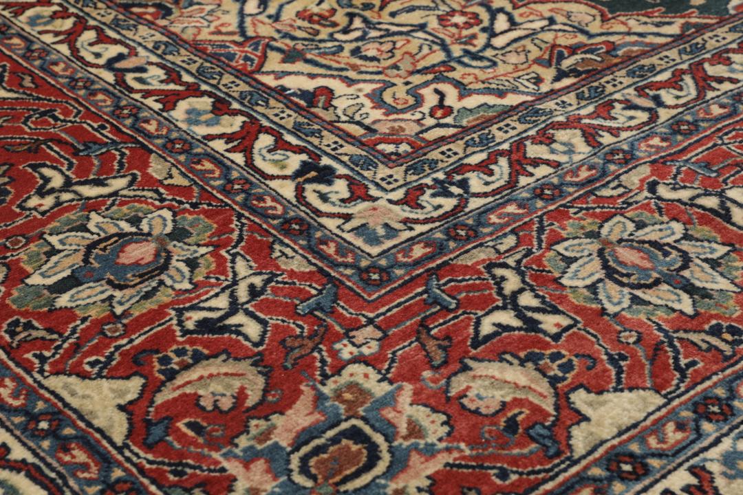 A hand-knotted Middle Eastern Sarough rug with a dark-blue field and floral patterns.