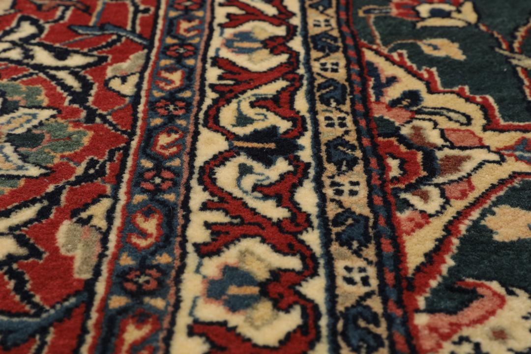 A hand-knotted Middle Eastern Sarough rug with a dark-blue field and floral patterns.