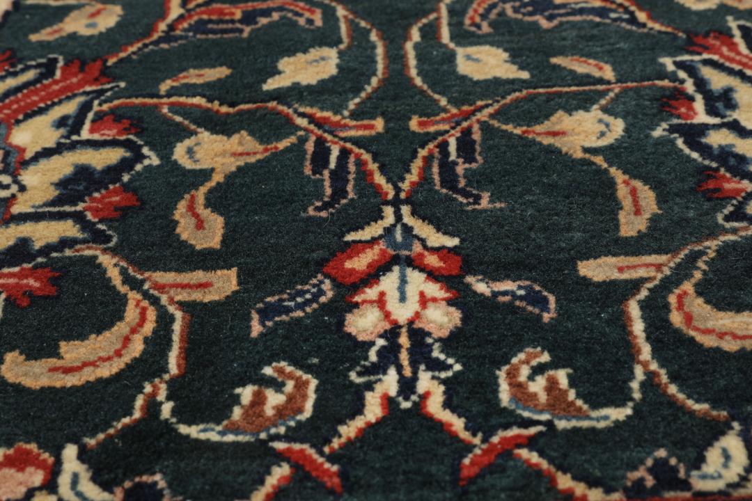 A hand-knotted Middle Eastern Sarough rug with a dark-blue field and floral patterns.