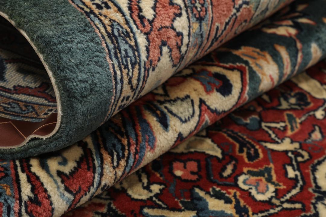 A hand-knotted Middle Eastern Sarough rug with a dark-blue field and floral patterns.