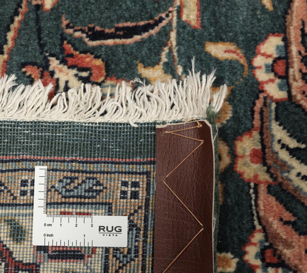 A hand-knotted Middle Eastern Sarough rug with a dark-blue field and floral patterns.