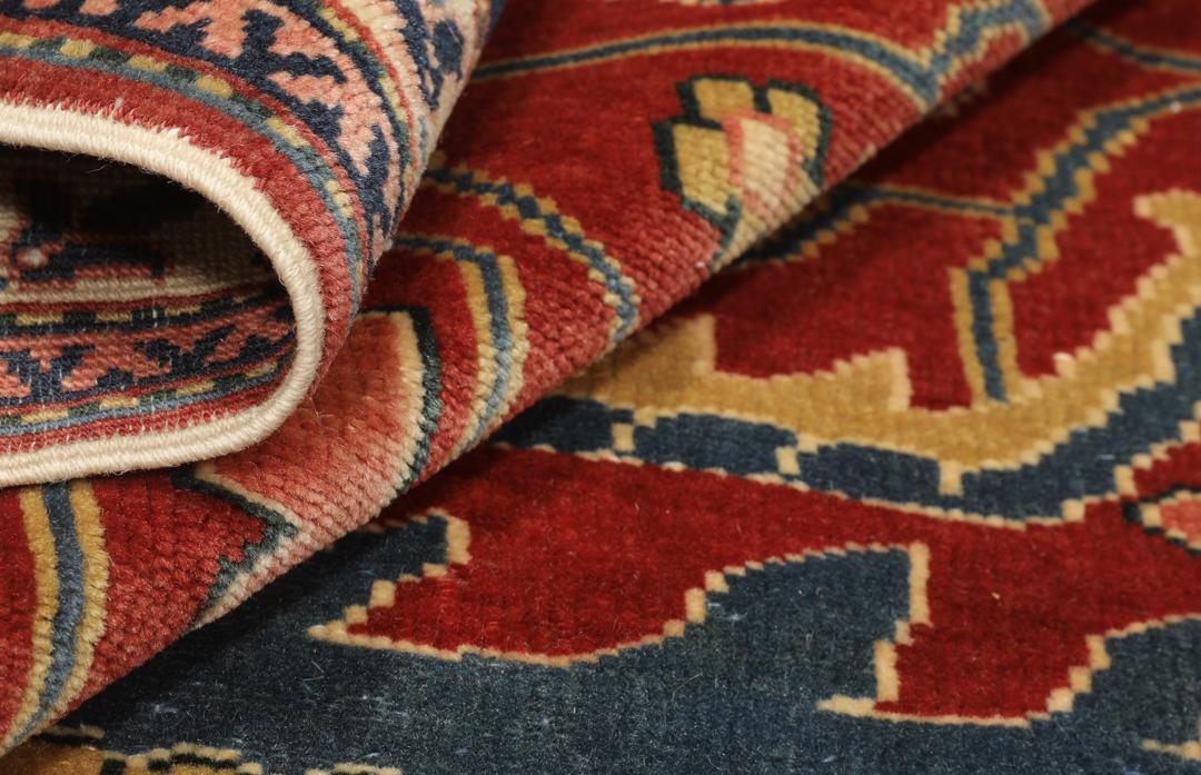 Vintage håndknyttet tyrkisk Shirvan-tæppe i rødt med ornamenterede blomster- og geometriske mønstre.