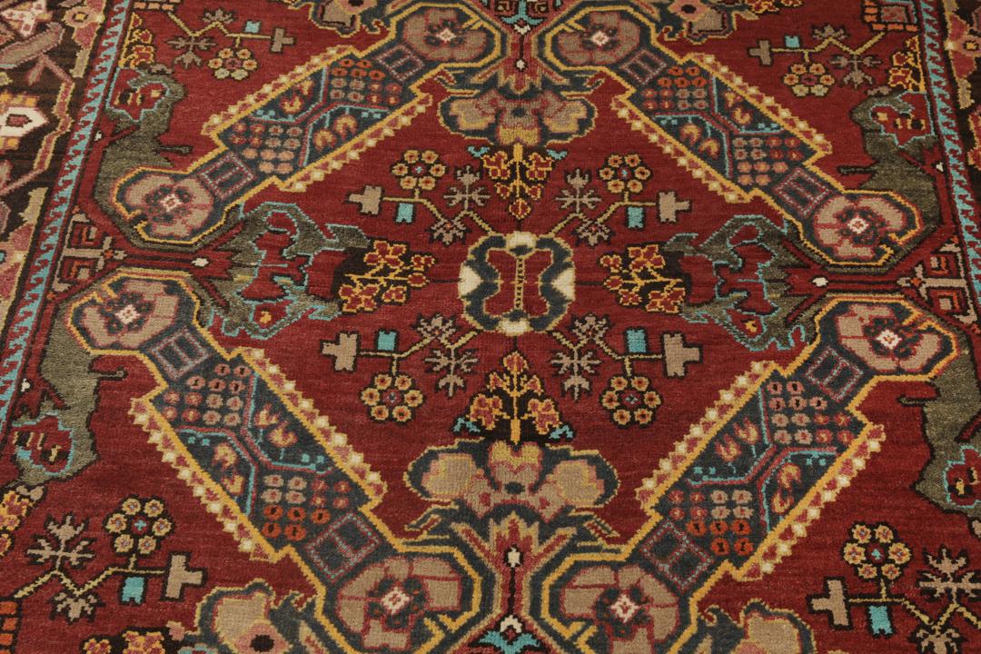 Antikt Shirvan-tæppe fra Mellemøsten med et levende rødt felt og komplekse geometriske motiver.