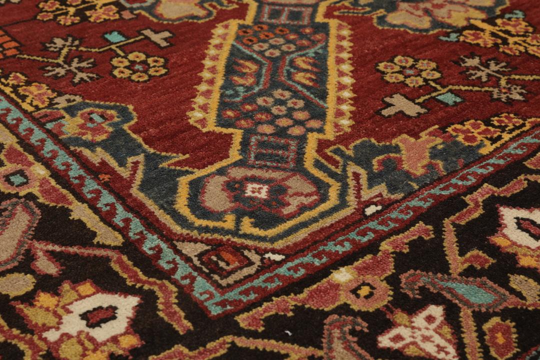 Antikt Shirvan-tæppe fra Mellemøsten med et levende rødt felt og komplekse geometriske motiver.