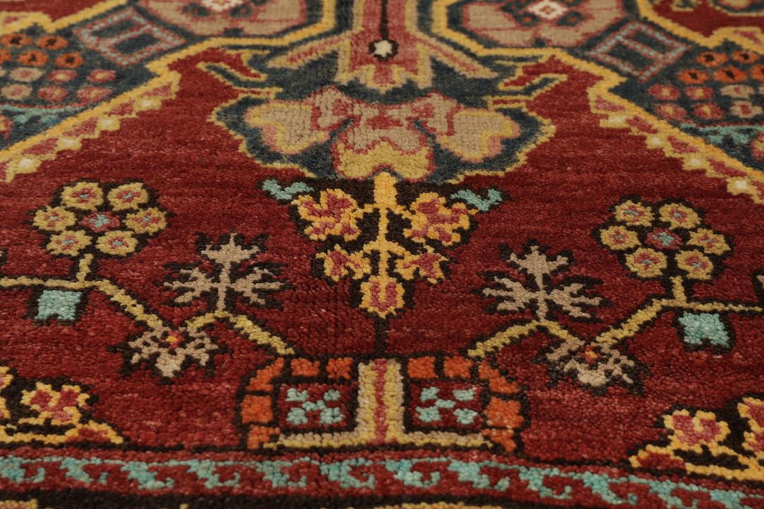 Antikt Shirvan-tæppe fra Mellemøsten med et levende rødt felt og komplekse geometriske motiver.