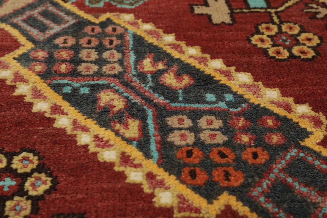 Antikt Shirvan-tæppe fra Mellemøsten med et levende rødt felt og komplekse geometriske motiver.