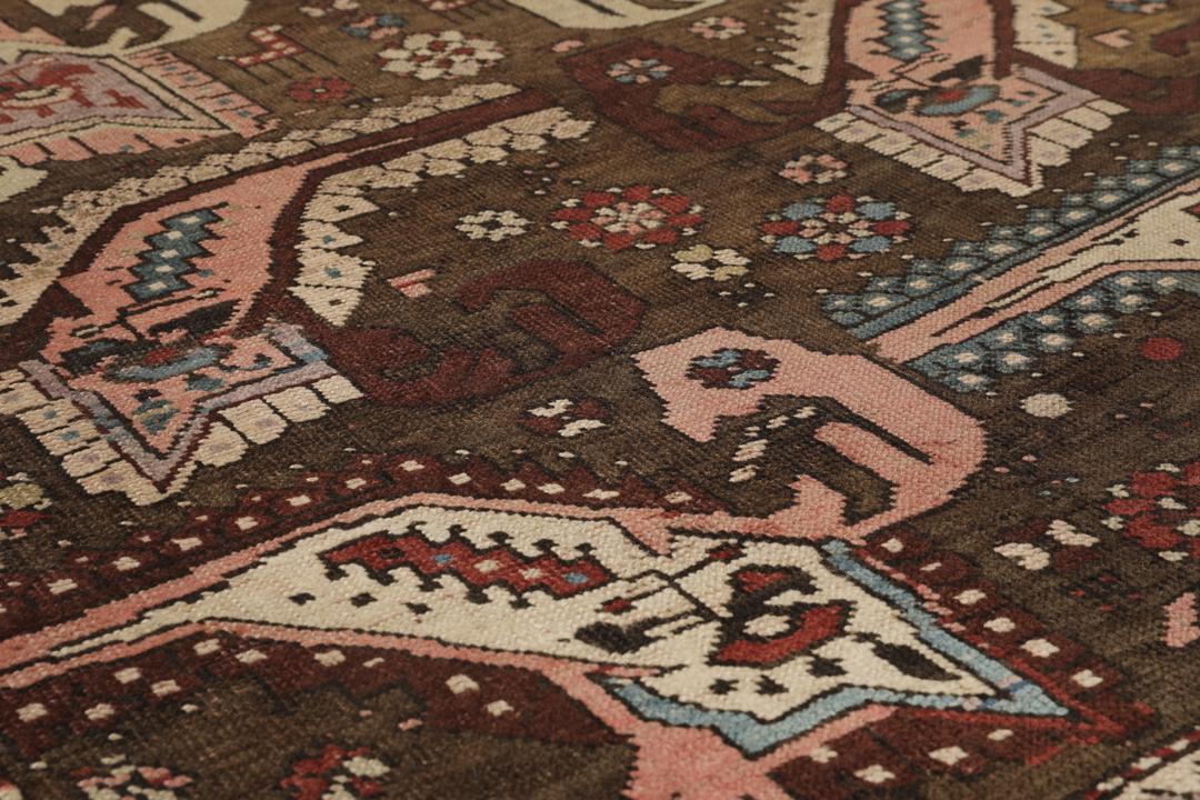 Antiek Shirvan-tapijt uit Azerbeidzjan, voorzien van een donkerbruine wollen pool met geometrische motieven.