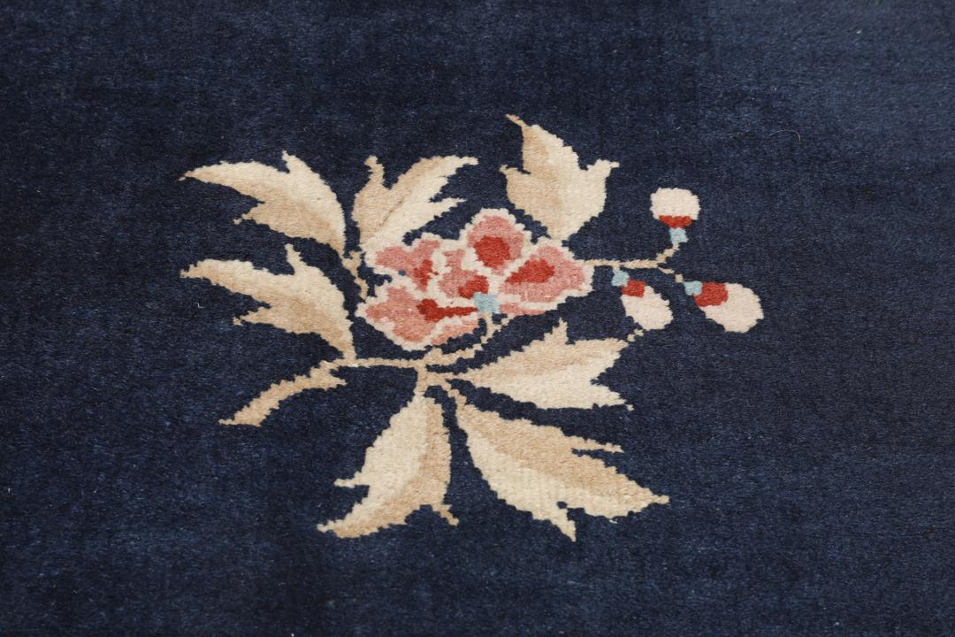Antik kinesisk løber med blomstermotiver på en mørkeblå baggrund