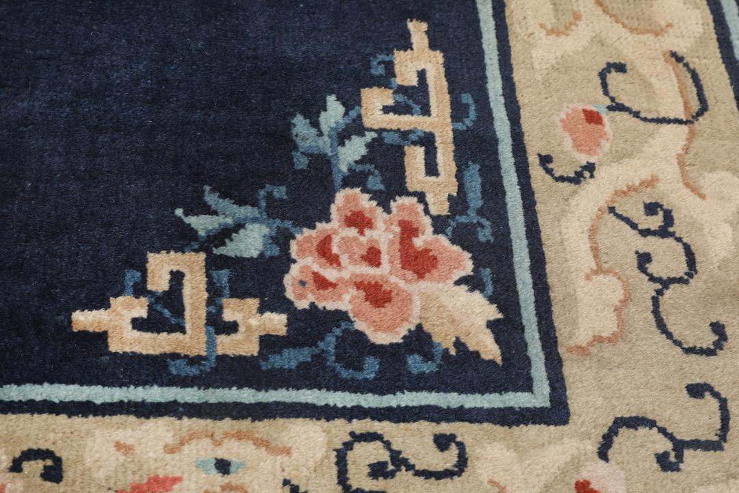 Antik kinesisk løber med blomstermotiver på en mørkeblå baggrund