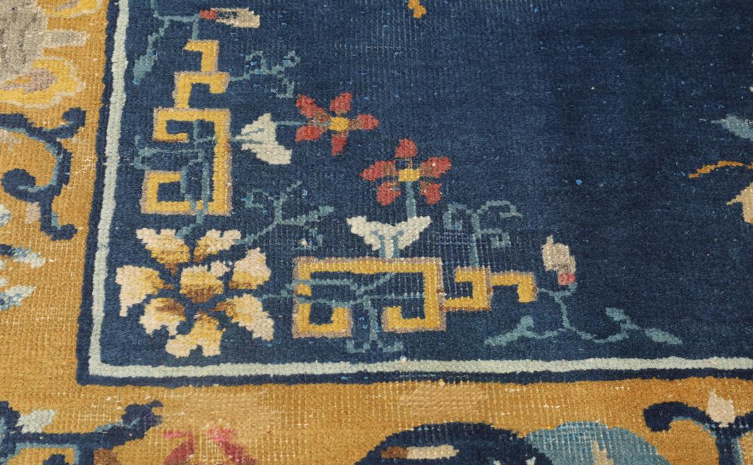 Antikt kinesisk Peking-tæppe med en mørkeblå flade og blomstermedaljonmønster