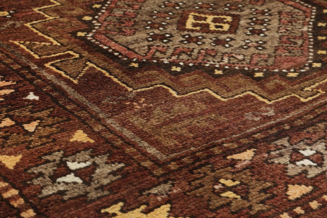 Antiek Shirvan-tapijt uit Turkije met traditionele geometrische patronen in bruintinten.