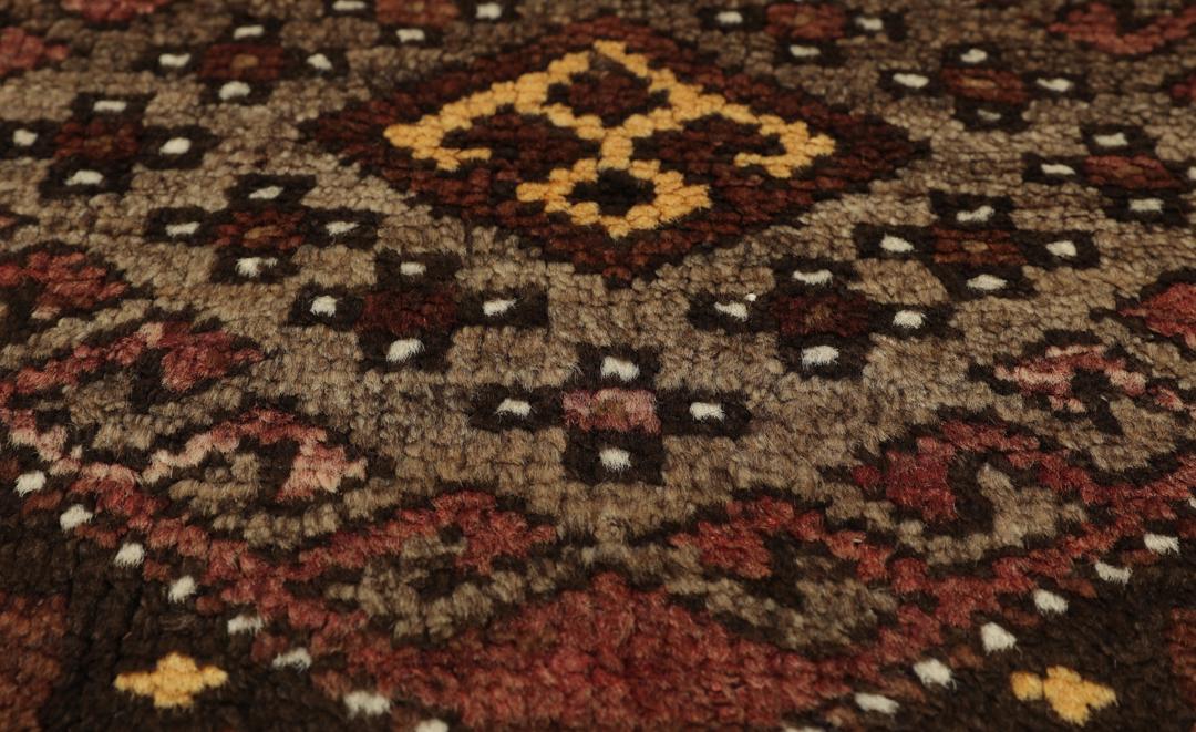 Antiek Shirvan-tapijt uit Turkije met traditionele geometrische patronen in bruintinten.