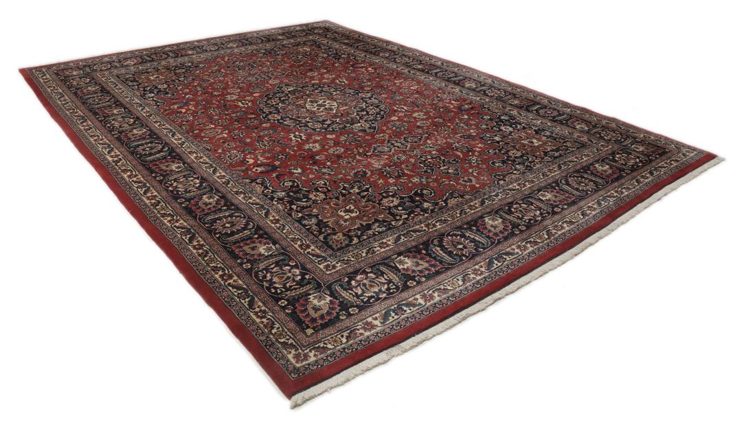 A large hand-knotted Mashad rug from the Middle East in deep red and blue tones