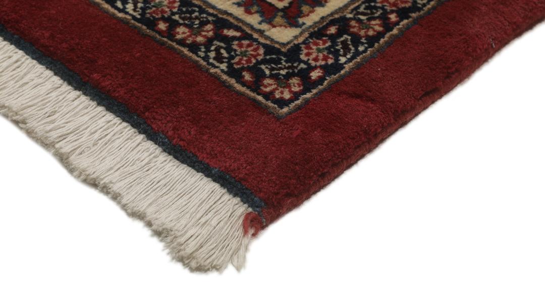 A large hand-knotted Mashad rug from the Middle East in deep red and blue tones