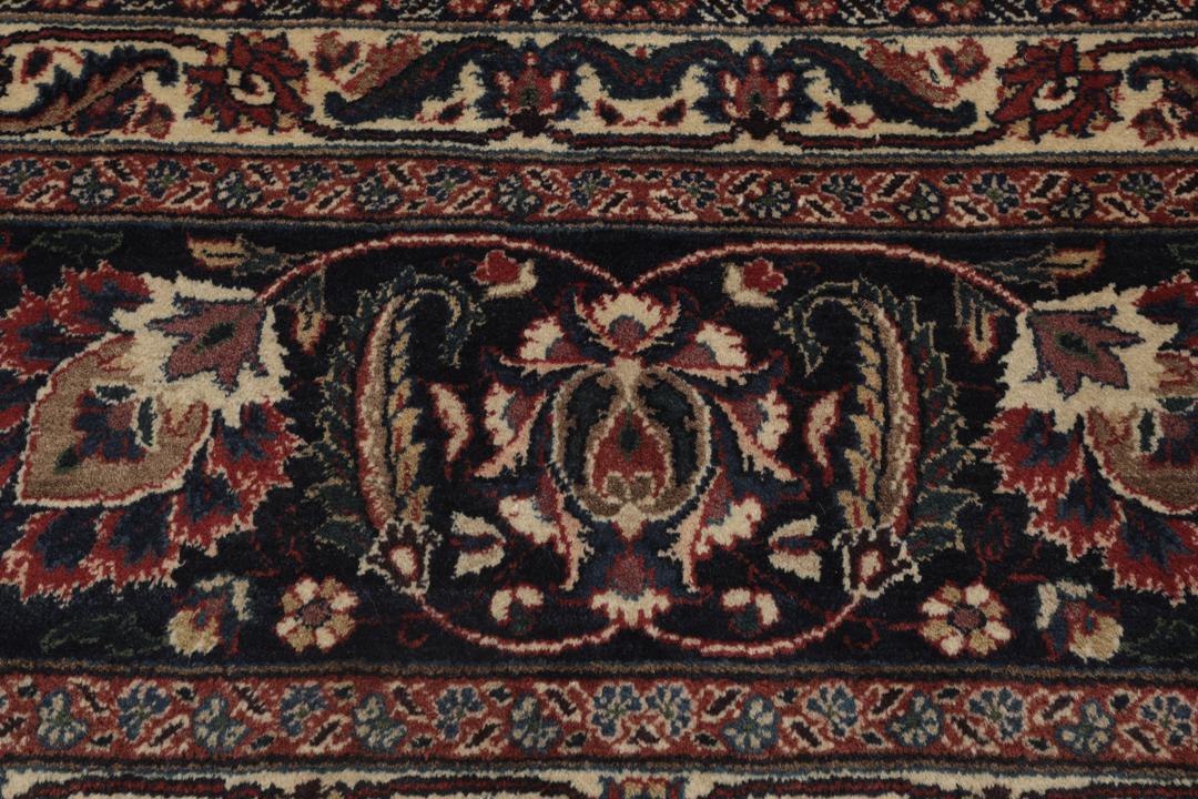 A large hand-knotted Mashad rug from the Middle East in deep red and blue tones