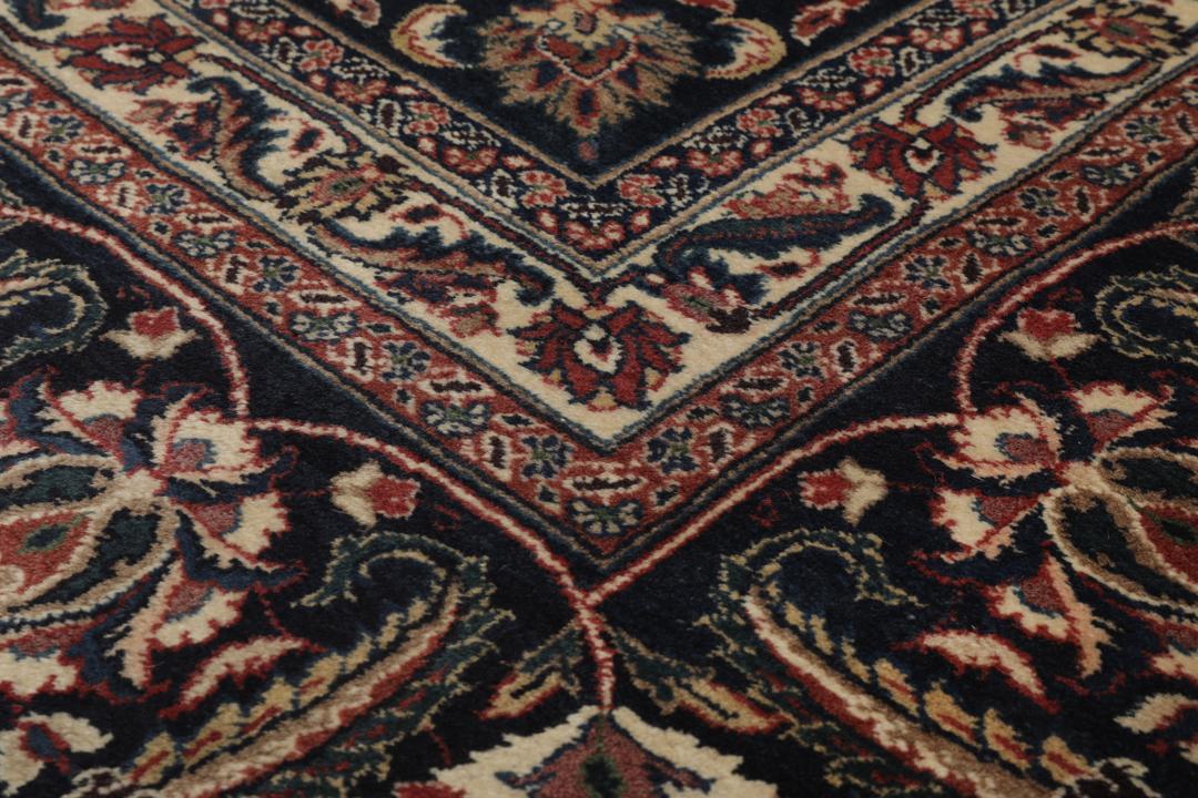 A large hand-knotted Mashad rug from the Middle East in deep red and blue tones