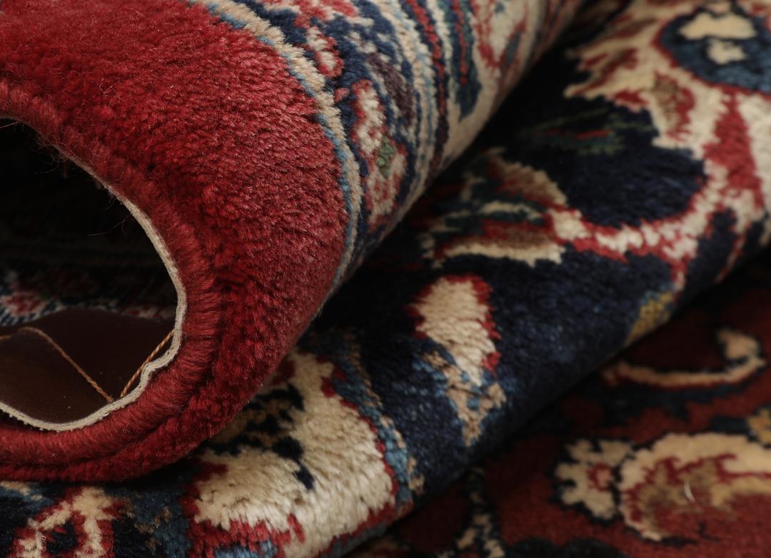 A large hand-knotted Mashad rug from the Middle East in deep red and blue tones