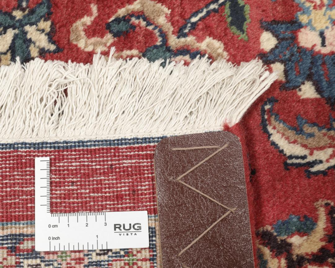 A large hand-knotted Mashad rug from the Middle East in deep red and blue tones