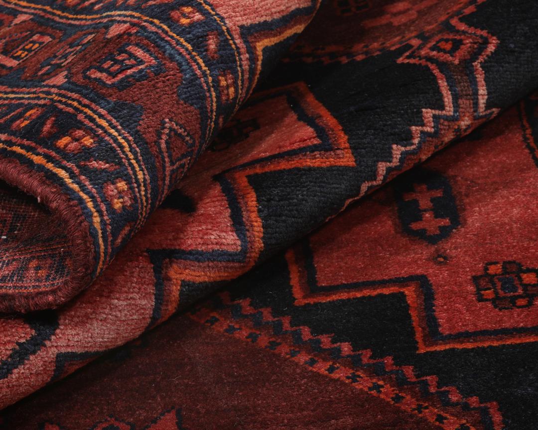 Een handgeknoopte Kurdi loper uit het Midden-Oosten met een levendig rood en zwart geometrisch patroon.