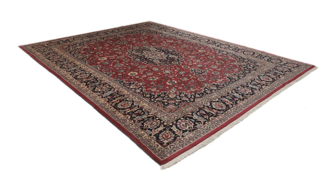 Hand-knotted Mashad rug from the Middle East in deep red and dark blue tones.