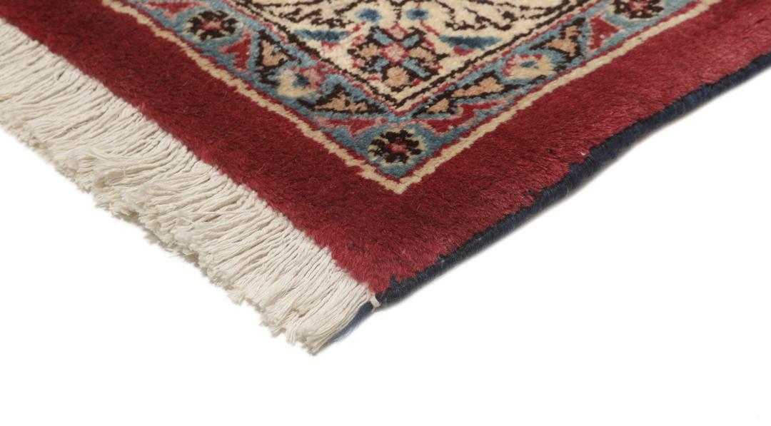 Hand-knotted Mashad rug from the Middle East in deep red and dark blue tones.