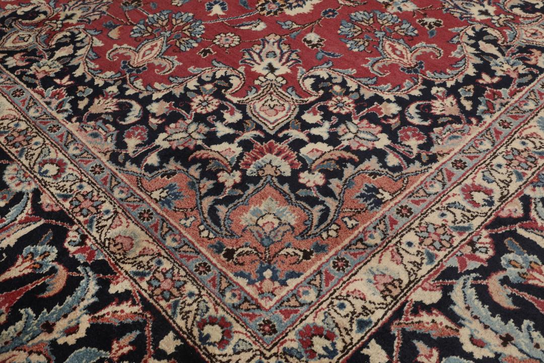 Hand-knotted Mashad rug from the Middle East in deep red and dark blue tones.