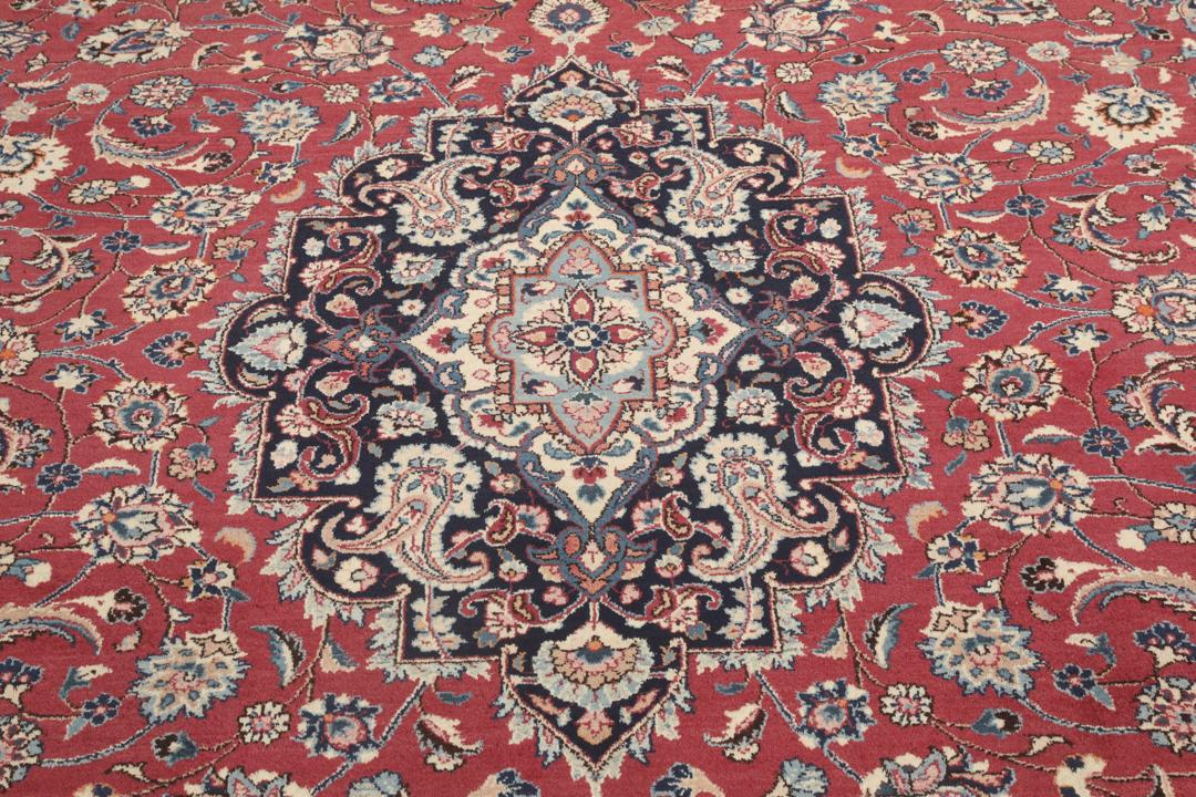 Hand-knotted Mashad rug from the Middle East in deep red and dark blue tones.