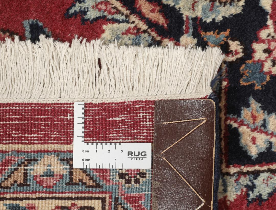 Hand-knotted Mashad rug from the Middle East in deep red and dark blue tones.