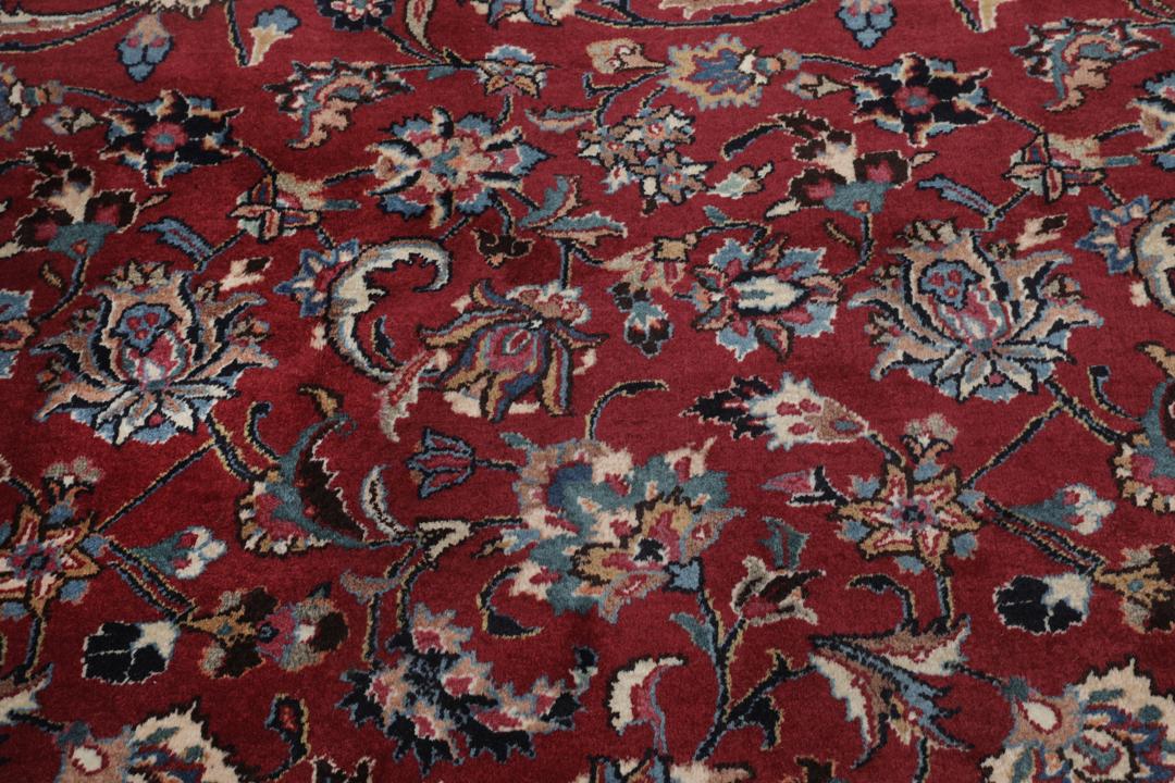 Hand-knotted Mashad rug from the Middle East in dark-red with floral pattern