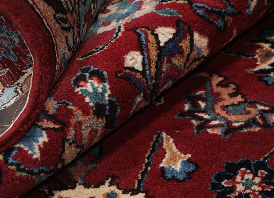 Hand-knotted Mashad rug from the Middle East in dark-red with floral pattern