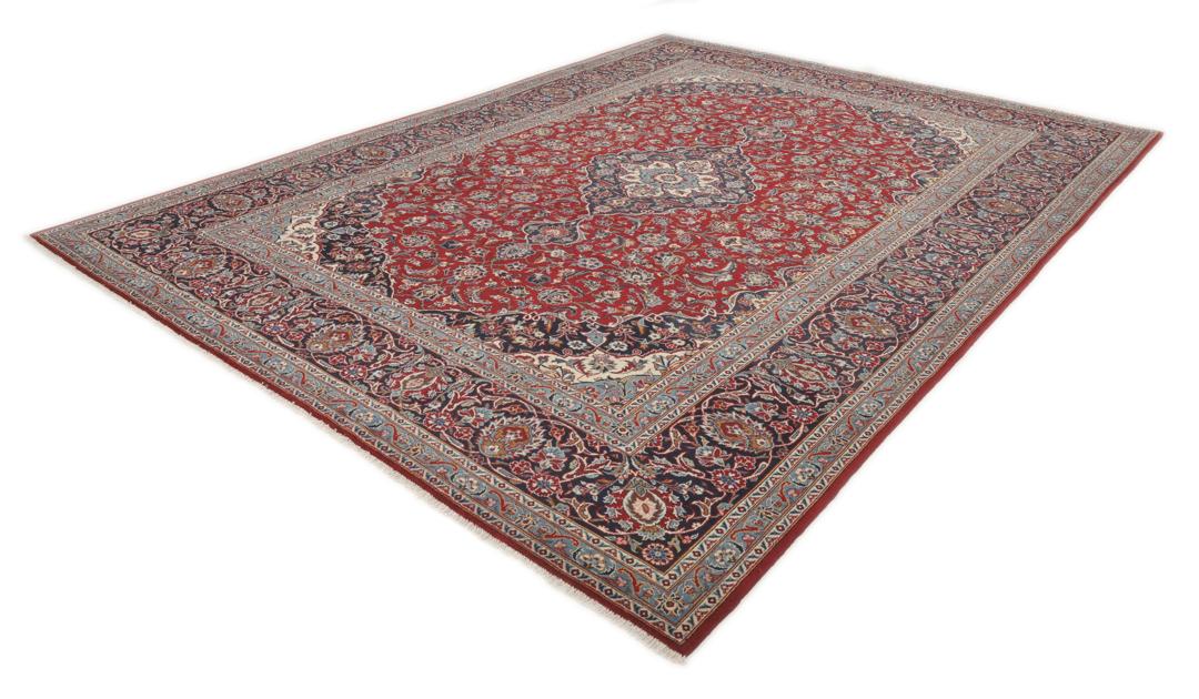 A hand-knotted Keshan rug from the Middle East with a red field and intricate floral patterns.