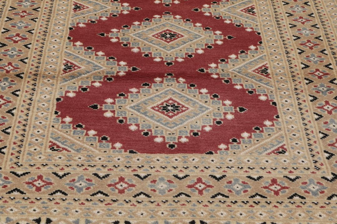 A hand-knotted red Pakistan Bokhara 2ply rug with geometric diamond motifs.