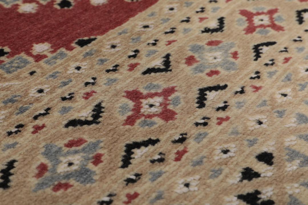 A hand-knotted red Pakistan Bokhara 2ply rug with geometric diamond motifs.