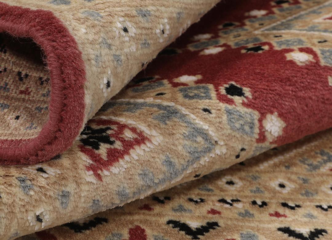 A hand-knotted red Pakistan Bokhara 2ply rug with geometric diamond motifs.