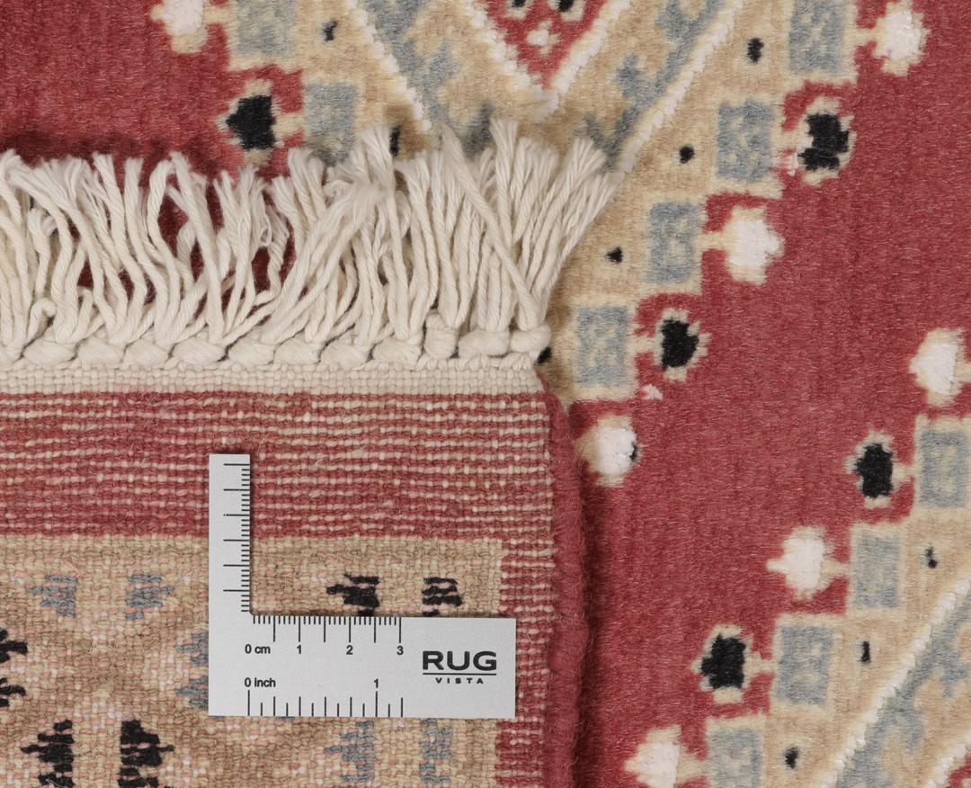 A hand-knotted red Pakistan Bokhara 2ply rug with geometric diamond motifs.