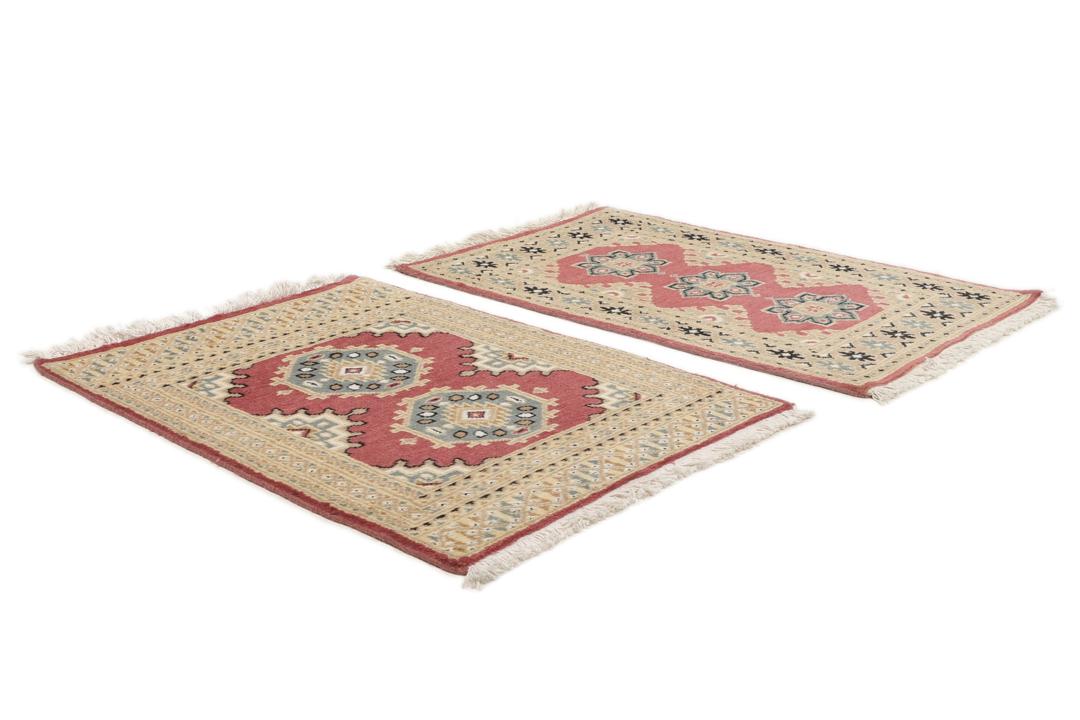 A hand-knotted Pakistan Bokhara rug in red and beige tones.