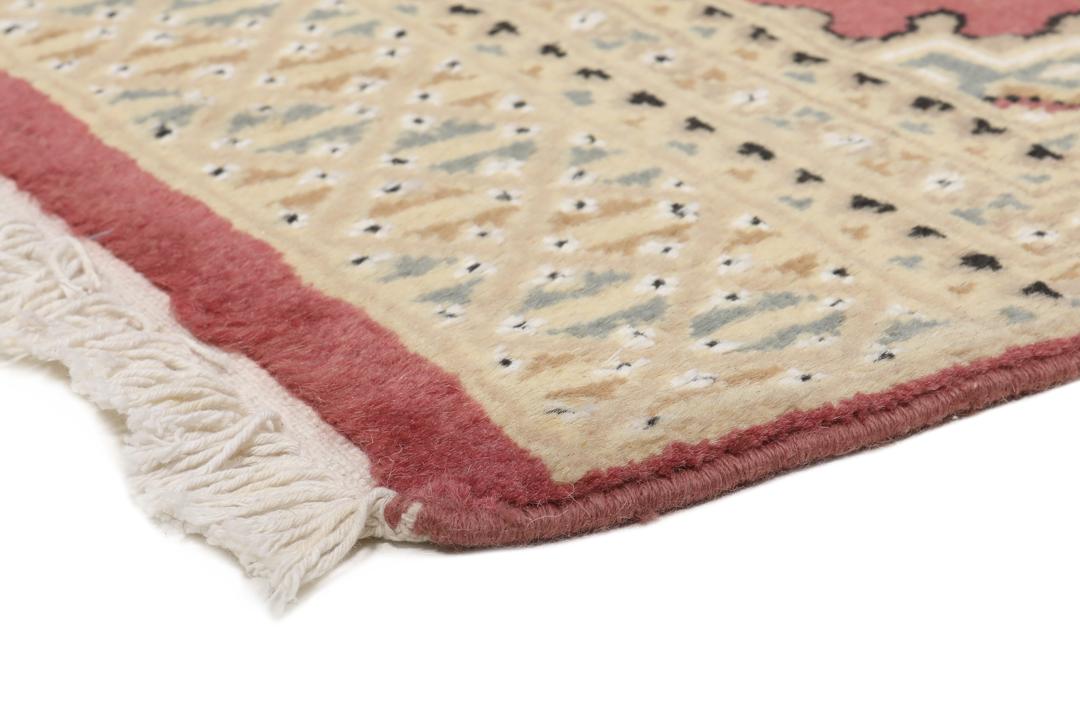 A hand-knotted Pakistan Bokhara rug in red and beige tones.