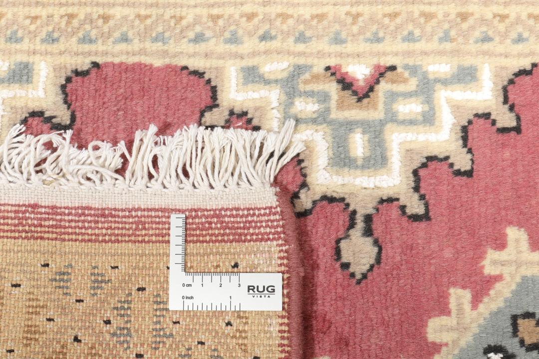 A hand-knotted Pakistan Bokhara rug in red and beige tones.