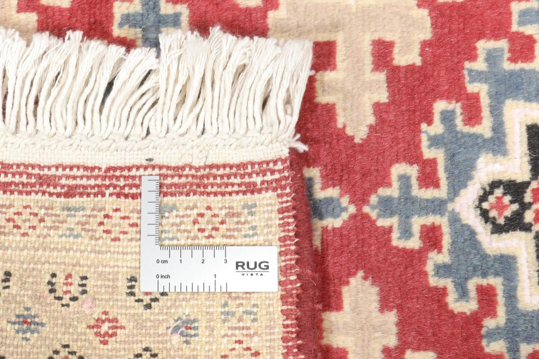A hand-knotted Pakistan Bokhara 2ply rug featuring geometric patterns in red and beige tones.