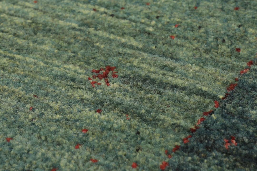 Et håndknyttet mellemøstligt Loribaft Fine-tæppe i mørkegrøn.