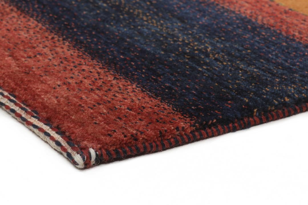 Hand-knotted Loribaft wool rug from the Middle East in red, orange, and blue.