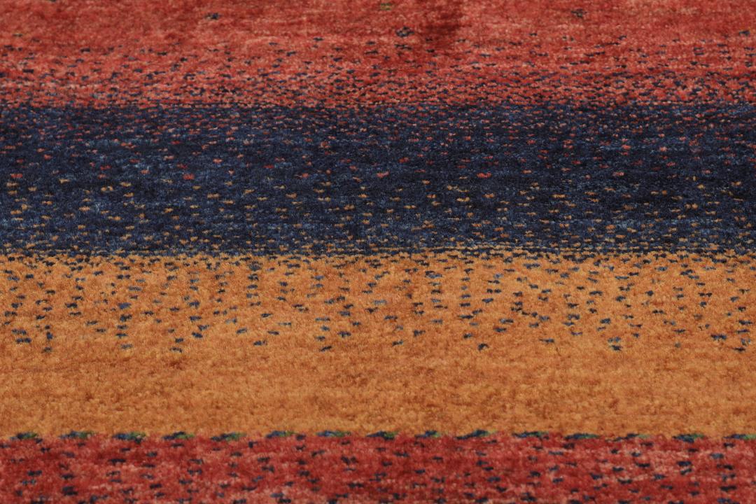 Hand-knotted Loribaft wool rug from the Middle East in red, orange, and blue.