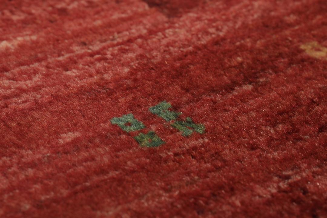 Un tapis Loribaft noué à la main originaire du Moyen-Orient dans une teinte rouge profonde.
