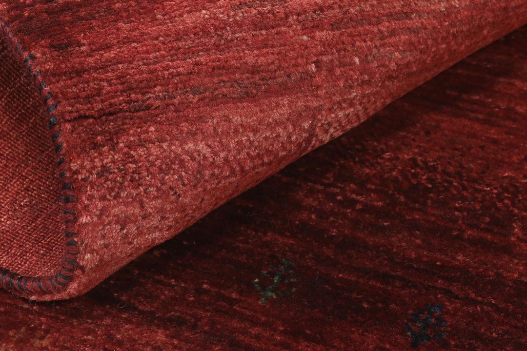 Un tapis Loribaft noué à la main originaire du Moyen-Orient dans une teinte rouge profonde.