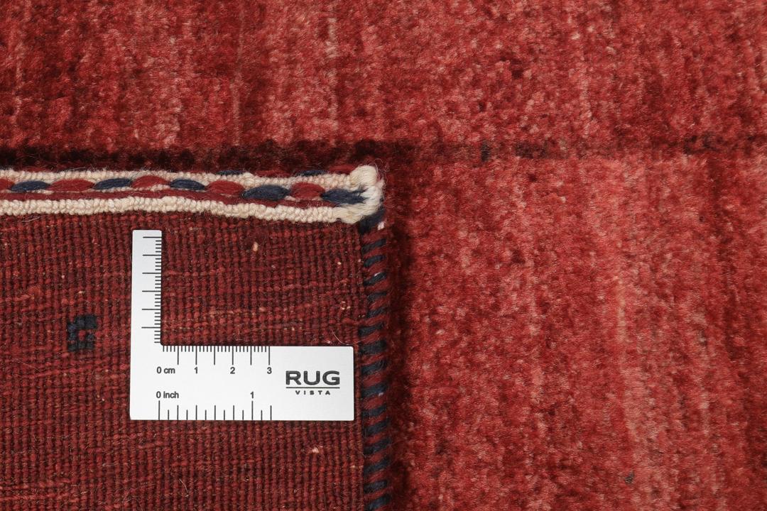 Un tapis Loribaft noué à la main originaire du Moyen-Orient dans une teinte rouge profonde.